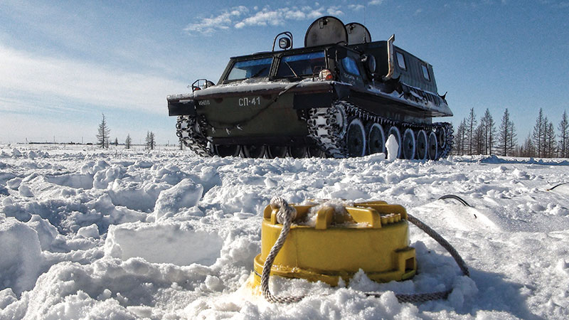 Putting cableless technology to the test: Old Russian military truck – carrying 206 ZLand seismic nodes and five people – sits behind a node buried up to the neck at the Russkoye oilfield. Photos courtesy of FairfieldNodal