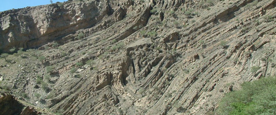A fold in geology is when one or a stack of originally flat and planar surfaces, such as sedimentary strata, are bent or curved as a result of deformation by pressures from faults and other forces of nature.