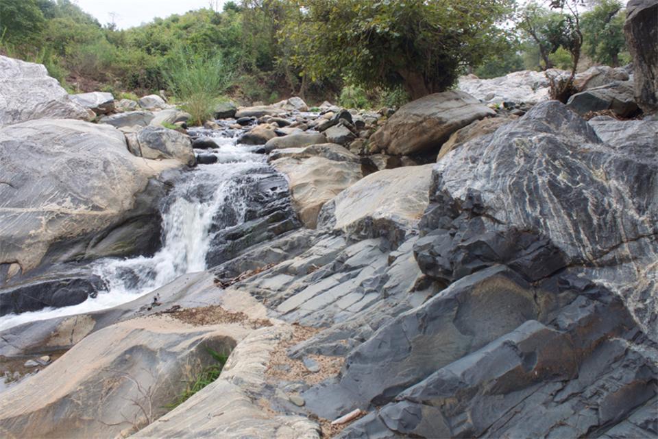 A stream flows along mafic dike that cuts Precambrian gneiss northeast of the Shire Valley, Malawi