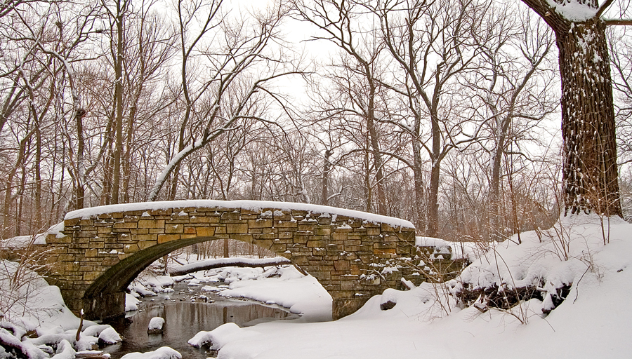 stone bridge over a creek in the snow