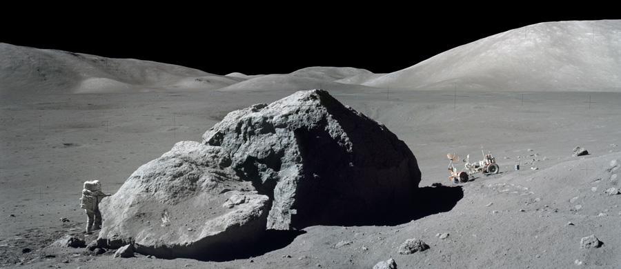 On Dec. 13, 1972, Schmitt stands next to a huge, split lunar boulder during the third Apollo 17 extravehicular activity at the Taurus-Littrow landing site. Photo by Eugene Cernan, courtesy of NASA.